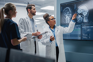 Three doctors checking a craneal radiography